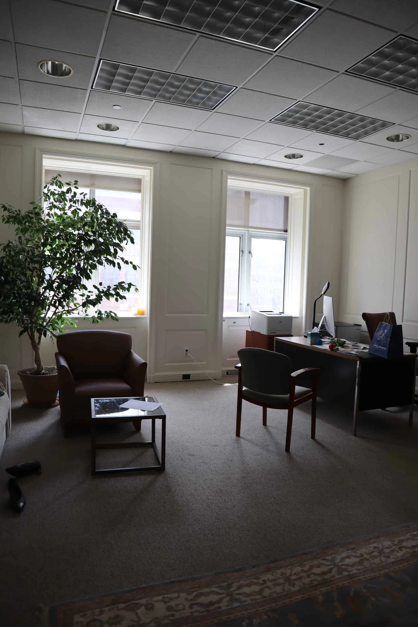 Modern office interior under renovation with exposed ceilings, tools, and construction materials.