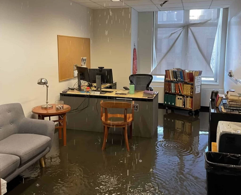 Flooded office with ceiling leak and standing water requiring emergency restoration by Green Island Group Corp